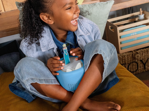 child playing with a frozen tonie and Toniebox Lite Cover Arctic Blue on a toniebox lite