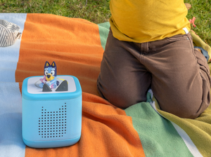 child playing with Toniebox 2, an audio player for kids with Bluey audio figurine