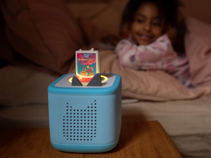 child smiling and listening to Roald Dahl Georges Marvellous Medicine Book Tonie on a blue toniebox 2