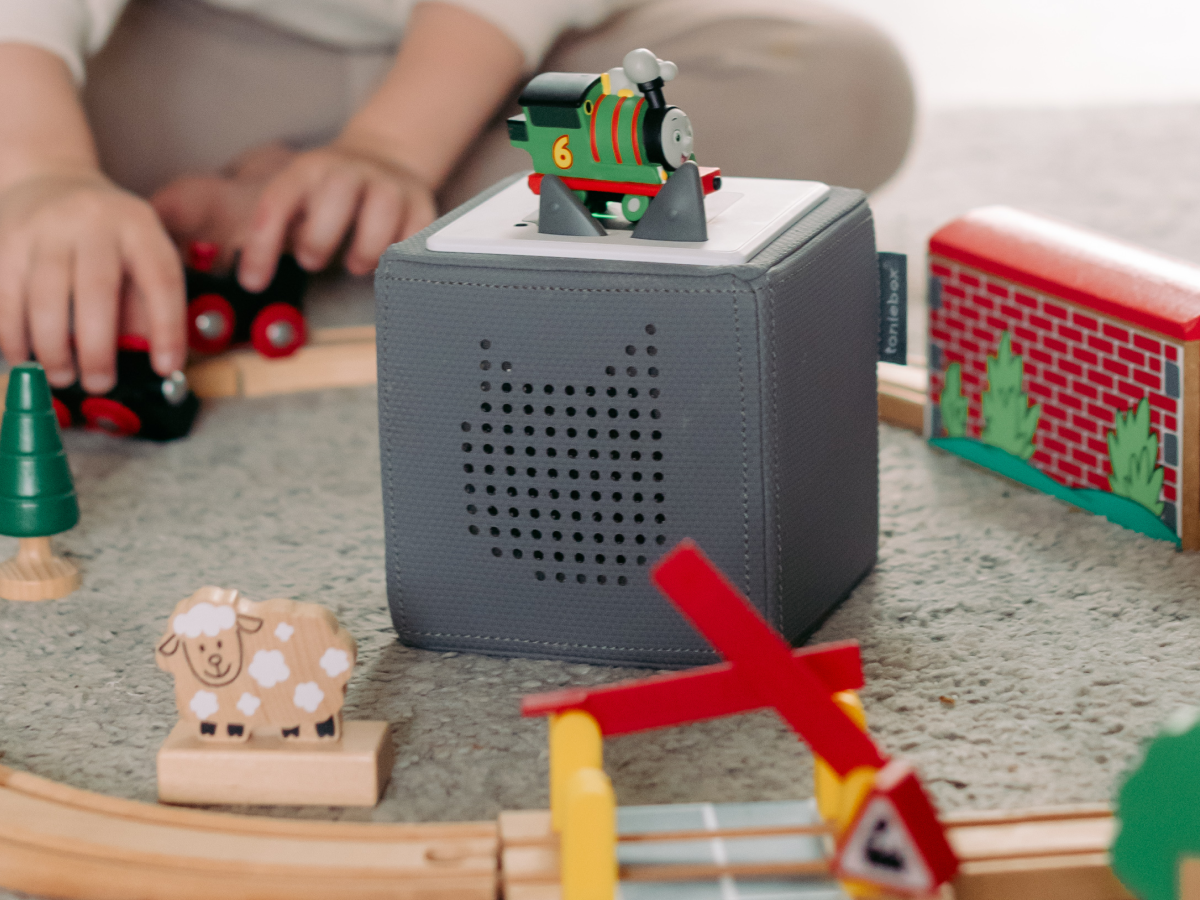 Child playing with All Engines Go: Percy Tonie audio figurine and Toniebox 2