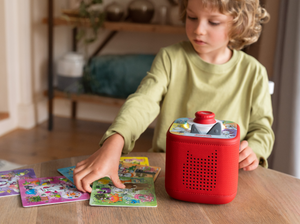 Child playing with Tonieplay Disney Pixar-Scene Searchers disc and a red toniebox 2